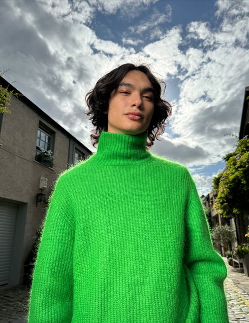 A photo shot on iPhone 15 Pro showing a person with a bright colored sweater and accurate skin tone